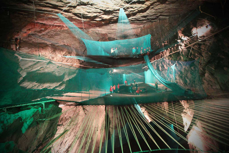 Illustration for article titled The Coolest Trampoline On Earth Is Suspended Inside a Huge Cavern
